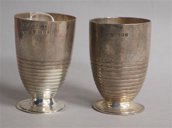 A stylish pair of George V ribbed silver beakers, on circular foot, Charles Boyton & Sons, London, 1932, 11 oz.